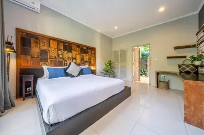 a bedroom with a large white bed with blue pillows at Villa Sarong 1 in Seminyak