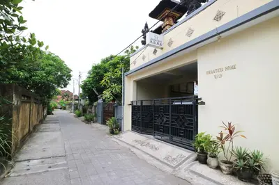 a street with a white building with a gate at Anantaya Home Denpasar in Denpasar