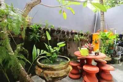 a garden with a table and a bunch of plants at Anantaya Home Denpasar in Denpasar