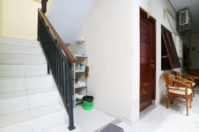 a staircase in a house with a wooden door at Anantaya Home Denpasar in Denpasar