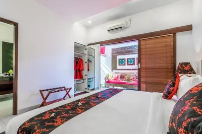 a bedroom with a large white bed with a window at Kamar Kamar Boutique Hotel in Seminyak