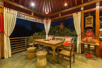 a room with a table and chairs on a balcony at Kamar Kamar Boutique Hotel in Seminyak