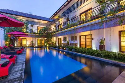 a swimming pool in front of a building at Kamar Kamar Boutique Hotel in Seminyak