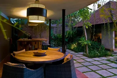 a patio with a wooden table and chairs on a patio at Komea Villa in Canggu