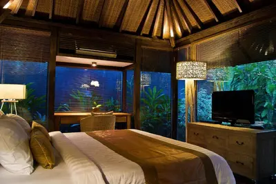 a bedroom with a bed and a television in a room at Komea Villa in Canggu