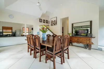 a dining room with a wooden table and chairs at Villa Seminyak William in Seminyak