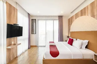 a hotel room with a large bed with a flat screen tv at Cove Villa Prana in Jimbaran
