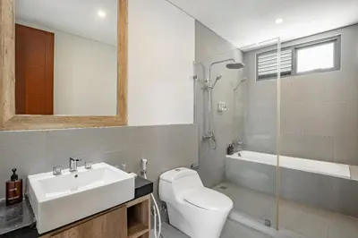 a bathroom with a sink and a toilet and a tub at Cove Villa Prana in Jimbaran