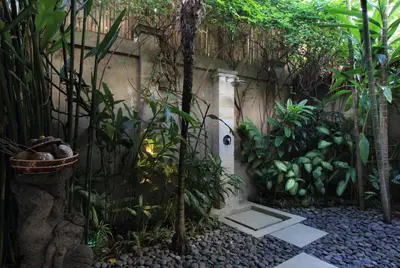a garden with a fence and some plants at Villa Maju in Seminyak