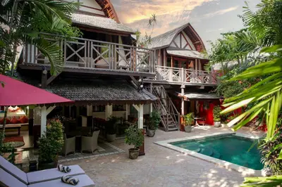 a resort with a swimming pool in front of a building at Villa Hangat in Seminyak
