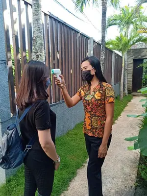 a woman taking a picture of another woman wearing a mask at Grania Bali Villas in Seminyak