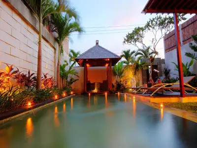 a swimming pool in front of a building with a gazebo at Grania Bali Villas in Seminyak