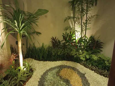 a garden with plants and a pattern on the ground at Grania Bali Villas in Seminyak