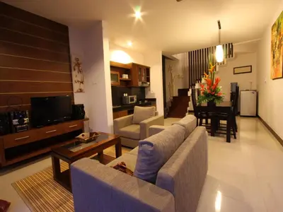 a living room with couches and a living room with a table at Grania Bali Villas in Seminyak