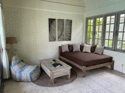 a living room with a couch and a coffee table at Artemis Villa Hotel in Seminyak