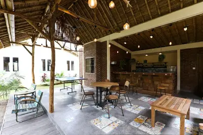 a patio with tables and chairs and a bar at Artemis Villa Hotel in Seminyak