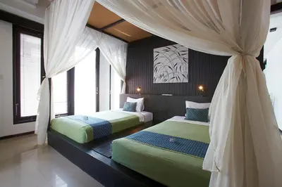 a bedroom with two beds and a canopy at Artemis Villa Hotel in Seminyak