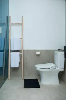 a bathroom with a toilet and a towel rack at Bloo Bali Hotel in Legian