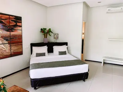 a bedroom with a large bed in a room at Casa Artista By Kresna Hospitality in Seminyak
