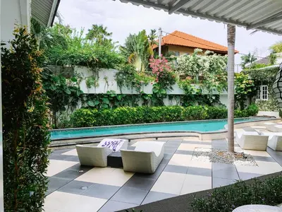 a swimming pool with lounge chairs next to a building at Casa Artista By Kresna Hospitality in Seminyak