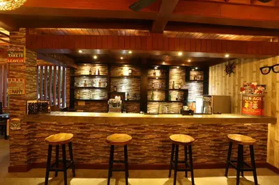 a bar with stools in front of a brick wall at The Jas Villas in Seminyak