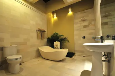 a bathroom with a toilet and a tub and a sink at The Jas Villas in Seminyak