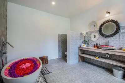 a bathroom with a large tub with flowers in it at Villa Maviba in Seminyak