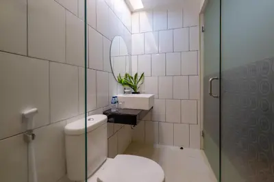 a bathroom with a toilet and a sink and a mirror at Everyday Hotel Kuta Central in Kuta