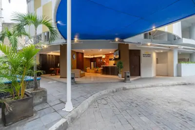 a building with a blue umbrella over a courtyard at Everyday Hotel Kuta Central in Kuta