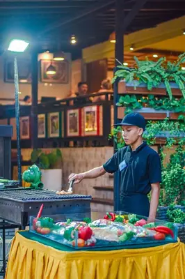 a man standing in front of a table with food at The Lokha Legian Resort & Spa in Legian