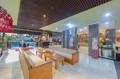a lobby with benches and tables in a building at The Lokha Legian Resort & Spa in Legian