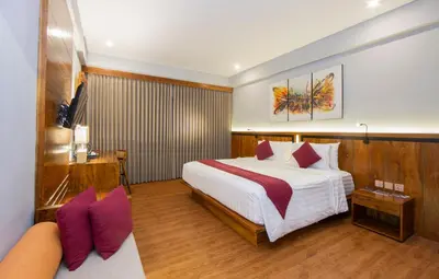 a hotel room with a bed and a couch at The Lokha Legian Resort & Spa in Legian