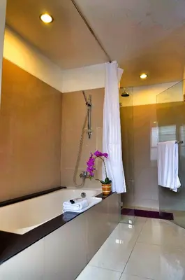 a bathroom with a bath tub and a sink at Sunset Residence and Condotel in Legian