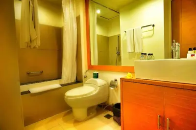 a bathroom with a toilet and a sink and a mirror at Sunset Residence and Condotel in Legian