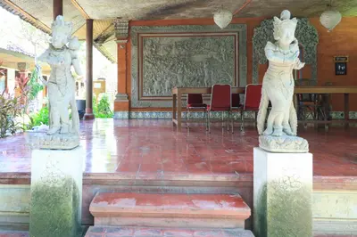 two statues of women in a room with chairs at Mertha Jati Hotel in Kuta