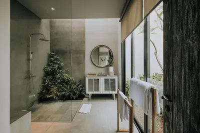 a bathroom with a shower and a mirror at Casamaya Villa in Legian