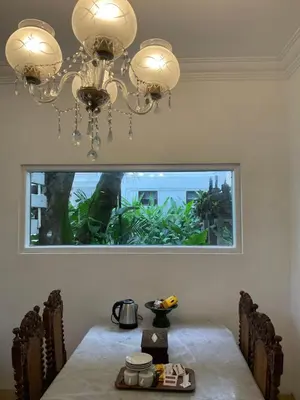 a dining room with a table and a chandelier at Grand Kumala Hotel - Hotel Kumala Legian Kuta Bali in Legian