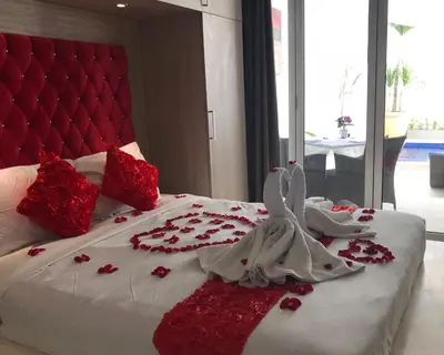 a bed with red and white flowers on it at Kuta Regency B10 One Bedroom Villa in Kuta