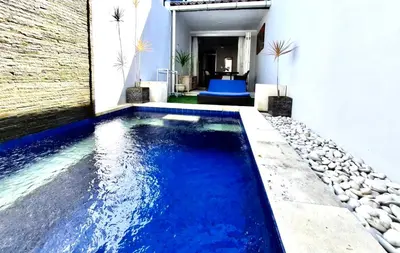 a swimming pool in the middle of a house at Kuta Regency B10 One Bedroom Villa in Kuta