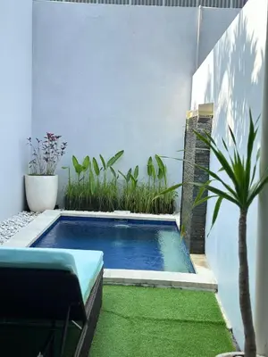a swimming pool in a backyard with a plant at Kuta Regency B10 One Bedroom Villa in Kuta