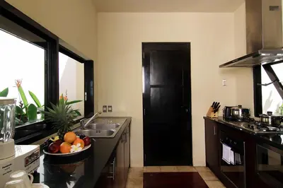 a kitchen with a black door and a bowl of fruit at Temple Hill Residence Villa in Jimbaran