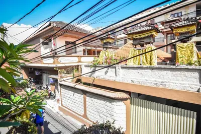 a building with yellow curtains on the balconies of it at Puri Agung Homestay in Kuta