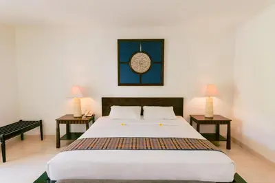 a bedroom with a large bed and two tables at Legong Keraton Beach Hotel in Canggu