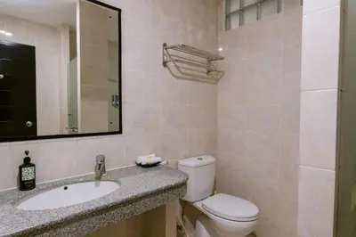 a bathroom with a toilet and a sink and a mirror at Legong Keraton Beach Hotel in Canggu