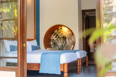 a bedroom with a bed and a mirror at Kecapi Villa Seminyak by Ini Vie Hospitality in Seminyak