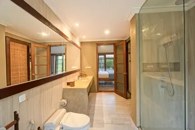 a bathroom with a toilet and a glass shower at Kecapi Villa Seminyak by Ini Vie Hospitality in Seminyak