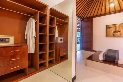 a bedroom with a closet with a bed and a microwave at Villa Dewata 3 in Seminyak