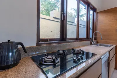a kitchen with a stove and a sink with a window at Villa Dewata 3 in Seminyak