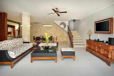 a living room with a couch and a tv at Villa Mawar Legian in Legian