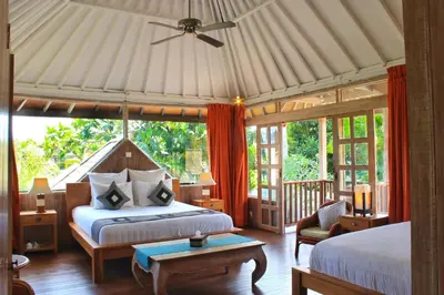 a bedroom with two beds and a ceiling fan at Villa Coconut Bali in Seminyak
